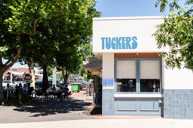 an exterior shot of Tuckers sandwiches cafe with outdoor dining and a leafy green tree