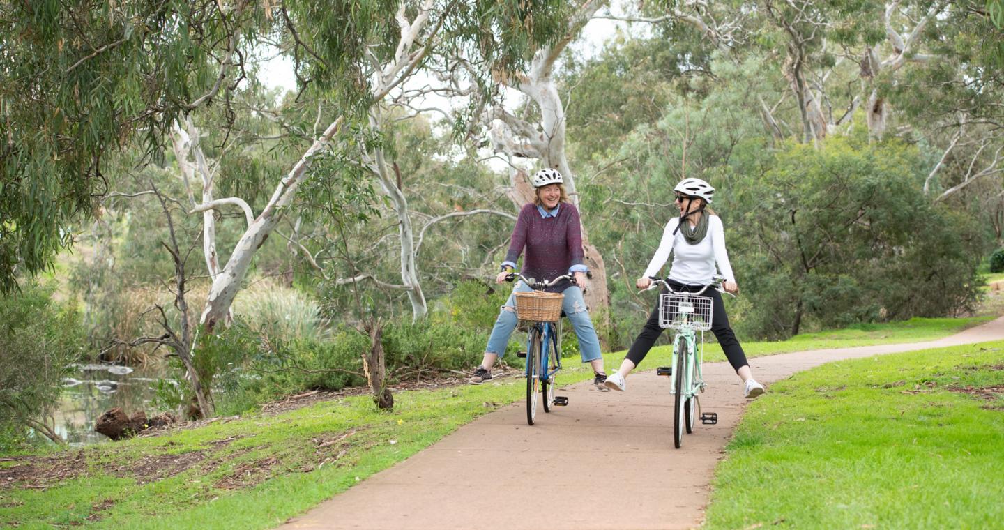 Two ladies riding bikes on trail