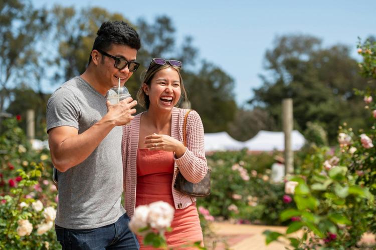 two adults in rose garden laughing