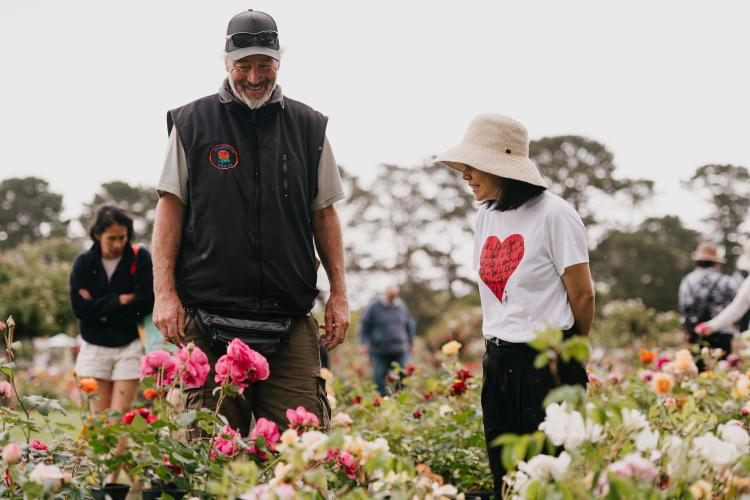 adults looking at flowers for sale and smiling