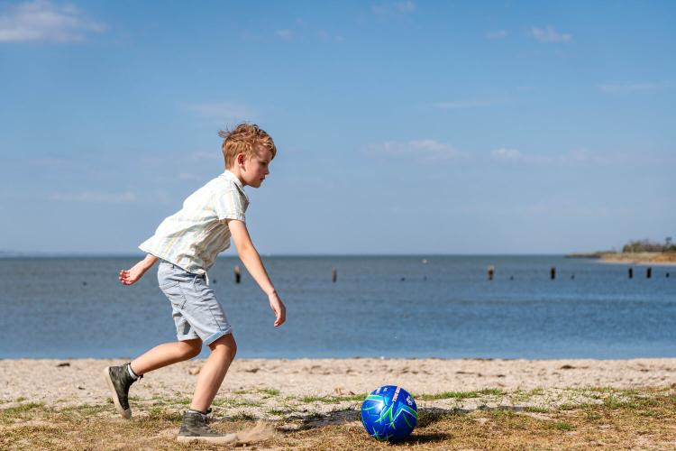 child with a ball on beach