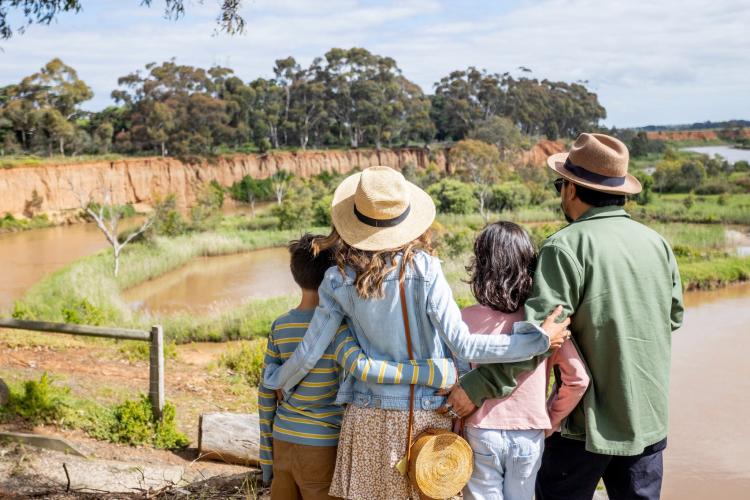 two adults and two children looking out at K Road Cliffs and Werribee River