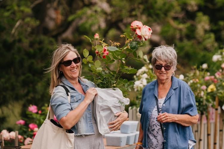 two adults with roses they have purchased smiling to camera