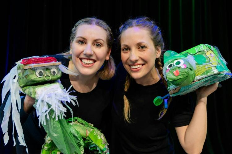 2 women each holding a puppet