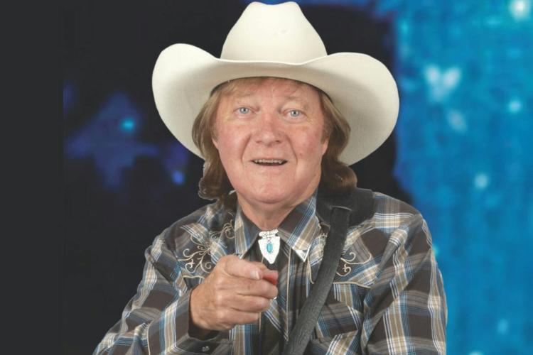 man points at camera earing cowboy hat