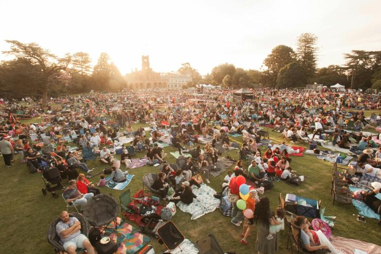 crowd gathered in front of Werribee Park Mansion at sunset