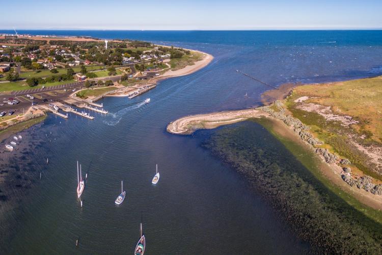 aerial of boats coming into the mouth of the Werribee River from Port Phillip bay.