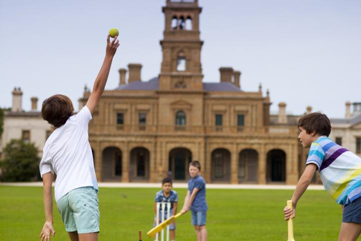Boys playing Cricket at Werribee Park in front of Mansion